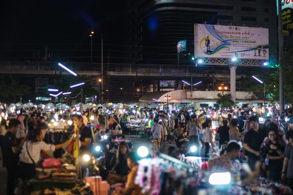 Crowds browsing food and market stalls at a Bangkok night market