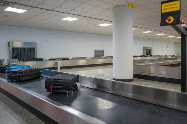 Suitcases on an airport baggage claim carousel with an empty belt behind them