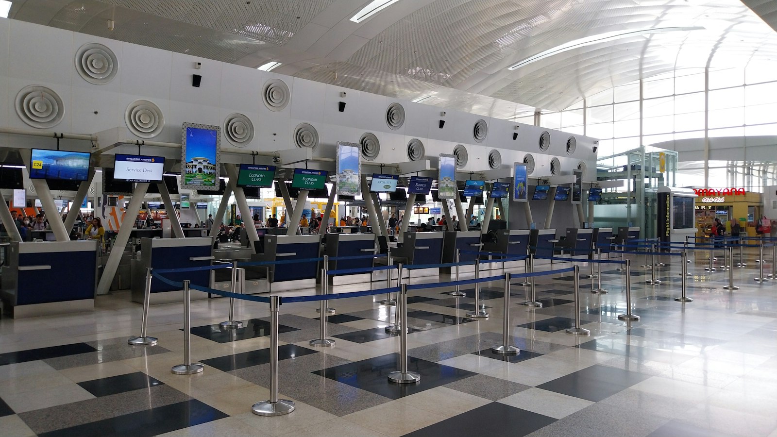 Airline check-in counters with empty queue lanes in an airport departures hall