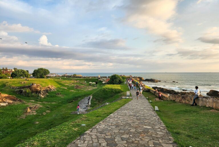 Walkers on the Galle Fort ramparts beside the Indian Ocean in Sri Lanka